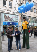 Stelzenlaeufer verteilt ballons